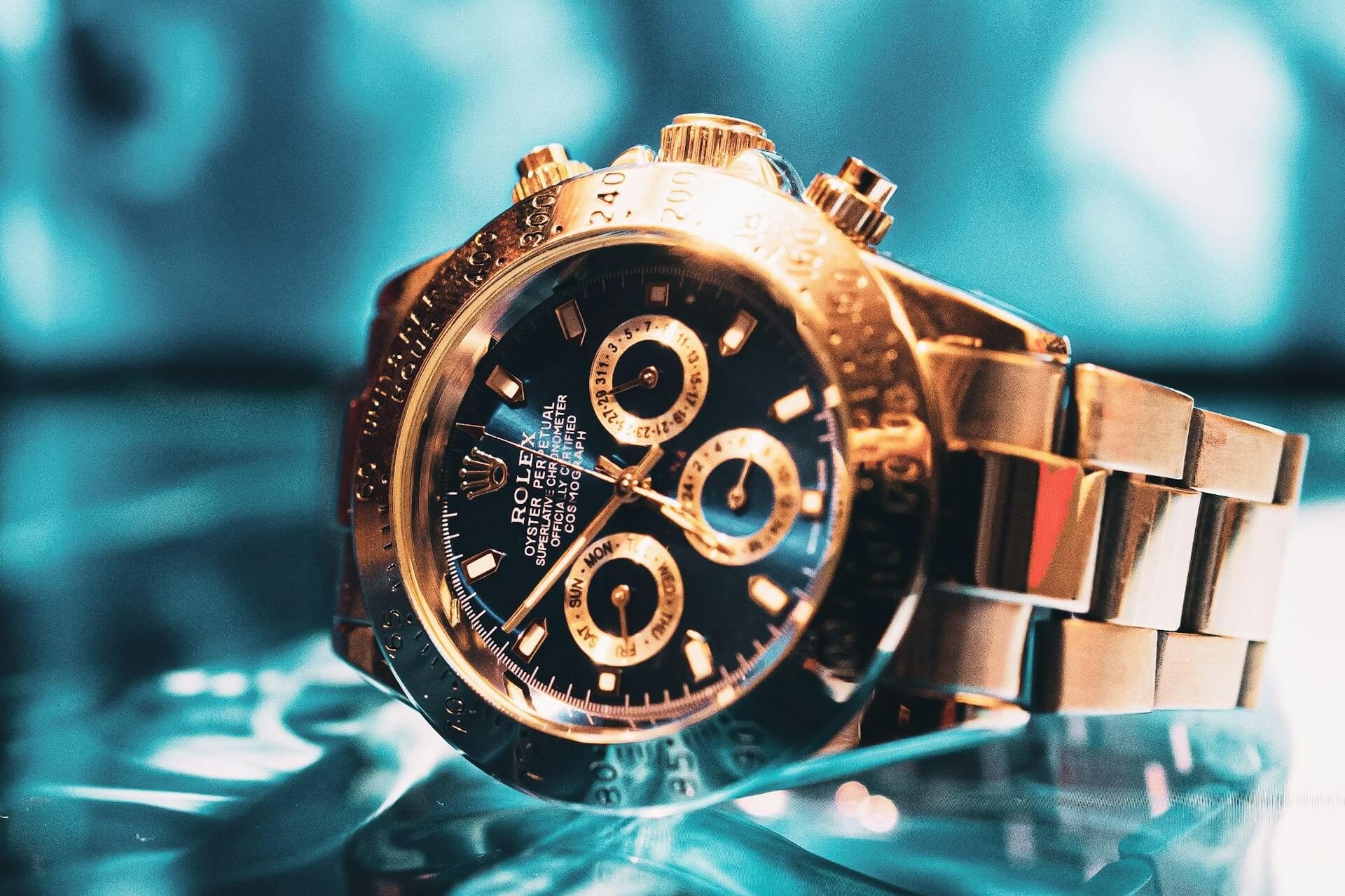 Reloj cronógrafo Rolex de oro expuesto en primer plano como símbolo de la garantía de autenticidad y el protocolo de verificación de Watch Club